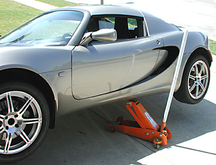 Lotus Elise lifted with a jack.